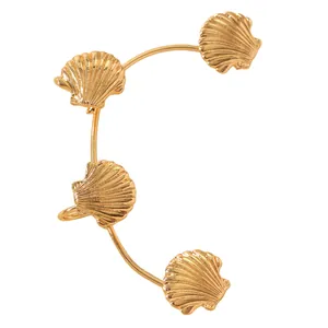 Dettaglio dell'ear cuff dorato con quattro ciondoli a forma di conchiglia