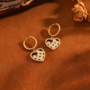 Vue détaillée de boucles d'oreilles créoles en forme de cœur avec zircone et perles