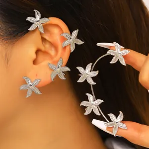 Dettaglio ravvicinato di un ear cuff a stella marina argentato indossato e tenuto