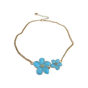 Elegant gold-tone necklace featuring two blue enamel flowers on white background