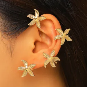 Primo piano di un elegante ear cuff a stella marina dorata con texture marina dettagliata