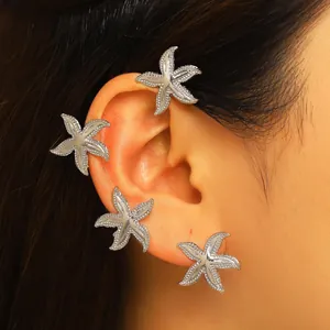 Primo piano di ear cuff a stella marina argentata con pietre luccicanti.