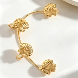 Dettaglio di un elegante polsino per orecchie a forma di conchiglia dorata