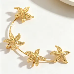 Dettaglio di un ear cuff dorato stile oceano con quattro stelle marine lucide
