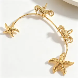 Vista dettagliata di un ear cuff dorato a tema oceanico con stelle marine e ippocampi