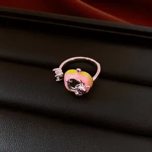 Macro detail of a whimsical pink and yellow enamel creature ring with a clear zircon stone
