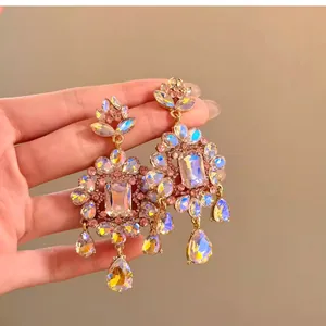 Close-up of vintage iridescent flower earrings with gold-tone finish and teardrop gems.