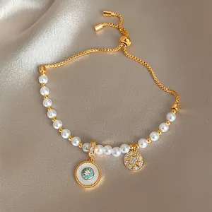 Gros plan d'un bracelet en perles plaqué or avec œil turquoise et pendentif fleur