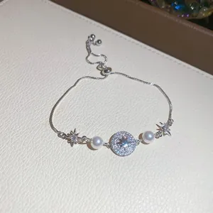 Detailansicht eines eleganten Silberarmbands mit Perlen und Sternmotiv, verstellbar.