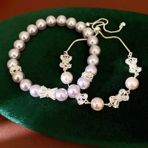 Elegant purple pearl bracelet set with sparkling zircon bow charms on green velvet