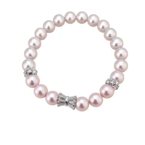 Elegant pink pearl bracelet with zircon-encrusted silver bow and floral accents.