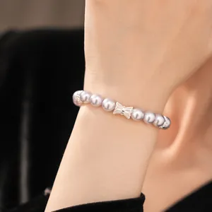 Close-up of a elegant lavender pearl bracelet featuring a sparkling zircon bow centerpiece.