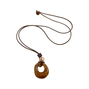 Vintage resin circle pendant necklace with brown cord and decorative wooden beads