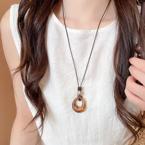 Close-up of a New Chinese style resin hollow circle necklace on a brown leather cord