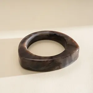 Vue détaillée d'un bracelet jonc triangulaire en résine avec marbrures sombres