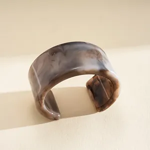 Vue détaillée d'un bracelet jonc en résine marbrée grise au design minimaliste