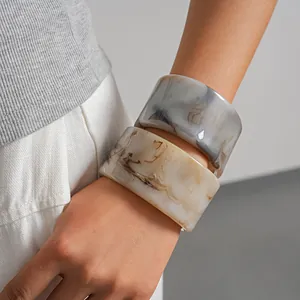 Vue détaillée de bracelets en résine marbrée minimalistes portés au poignet pour femme