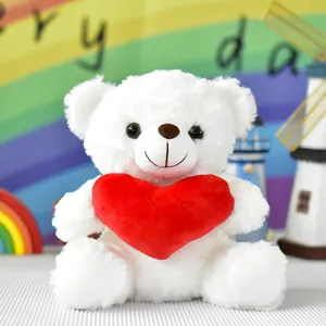 Dettaglio di un morbido orsetto di peluche bianco con un cuore rosso