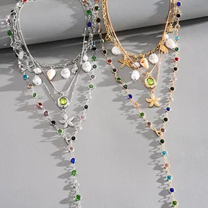 Close-up of layered necklaces with starfish, seashells, and pearls in gold and silver finish