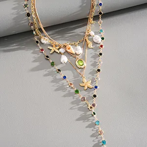Macro shot of multilayer gold necklace featuring resin conch, starfish, and colored beads