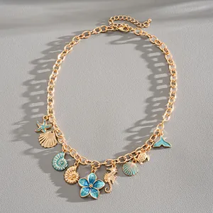 Macro view of gold chain necklace featuring blue enamel starfish and shell charms