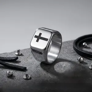 Détail en gros plan d'une bague chevalière en acier inoxydable avec une croix noire gravée