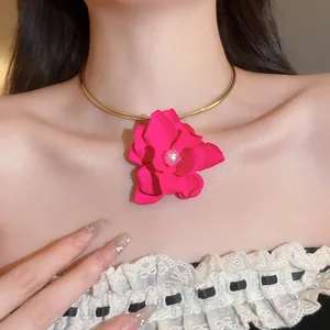 Vista dettagliata di un elegante choker con fiore rosa e perla su collana dorata