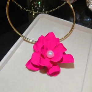 Primo piano di girocollo con fiore rosa vibrante e perla centrale
