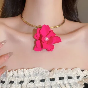 Primo piano dettagliato della collana girocollo fucsia con fiore e perla centrale su modella