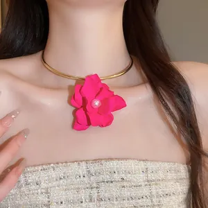 Elegante choker con fiore in tessuto rosa acceso e centro in perla indossato da modella