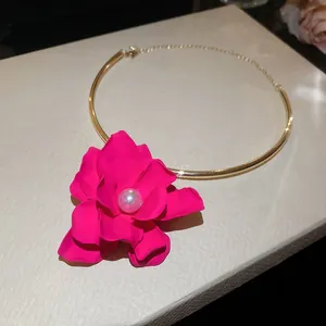Dettaglio girocollo con fiore fucsia, perla centrale e fascia dorata
