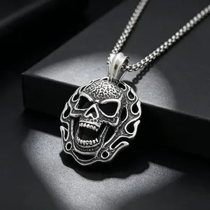 Vue détaillée d'un pendentif crâne punk en acier titane avec bord flamme et texture moulée