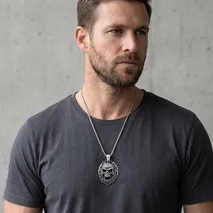 Détail du collier pendentif tête de mort punk pour homme sur t-shirt gris