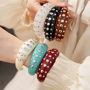 Detail van dikke hars armbanden met gepolijste metalen klinknagels in meerdere kleuren