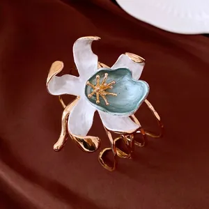 Retro gold open bracelet featuring a large white and blue enamel wrinkled flower design