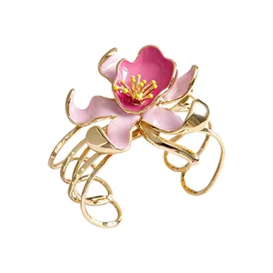 Vintage gold-tone cuff bracelet featuring a large layered pink enamel flower design