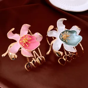 Detailed view of elegant gold-toned floral cuff bracelets with enamel petals