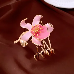 Detail of a retro pink enamel flower cuff bracelet with a gold-tone tiered metal band