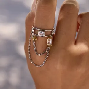 Detailansicht eines Edelstahlrings mit hängenden Ketten und rechteckigen Zirkonias.