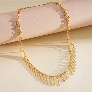 Detailed macro view of retro gold necklace featuring elegant metallic copper bar fringe