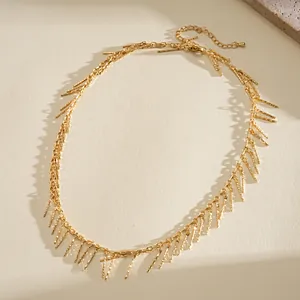 Elegant gold fringe necklace featuring textured copper bars on a warm textured background.