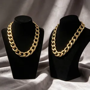 Lujosos collares de cadena gourmette dorada tipo hip hop mostrados en elegantes bustos negros
