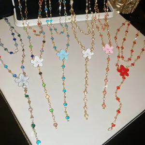 Detalle de varios conjuntos de collar y pulsera con flores de esmalte de colores.