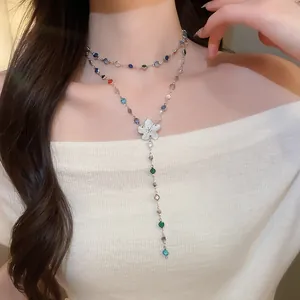 Vista detallada de collar en Y con colgante de flor y gemas de colores en modelo real