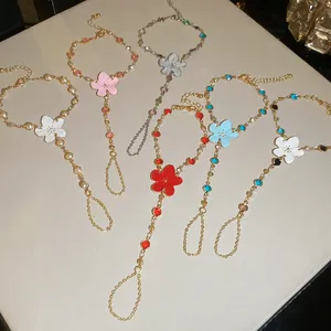 Detalle de pulseras de mano con flores de esmalte en varios colores vivos