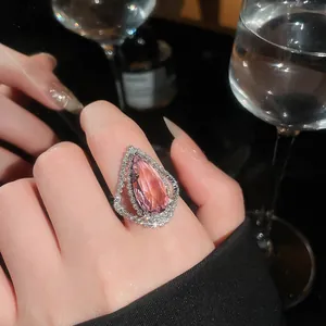 Detailed view of a luxury pink pear-cut gemstone ring with a double sparkling diamond halo