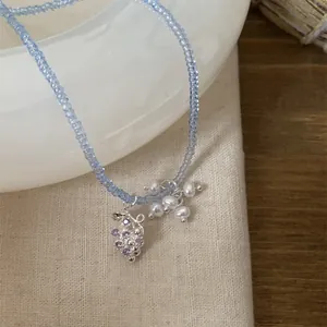 Vue détaillée d'un collier de perles bleu clair avec pendentif raisin et perles