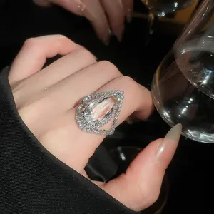 Close-up of a luxury teardrop-shaped ring with pavé-set crystals on a model's hand.