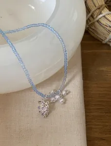 Vue détaillée du pendentif raisin et des perles sur un collier de perles bleues