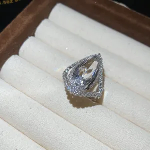 Macro view of teardrop halo ring featuring a large central stone and pave setting.